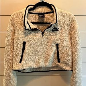 A lightly worn white and black Nike women’s fleece crop top, quarter zip up.